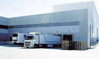 Os caminhões de carga descarregam no armazém como parte das operações de cross-docking