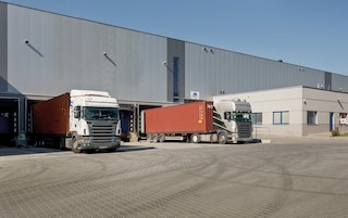 Caminhões atuando no recebimento de mercadorias nas docas do armazém