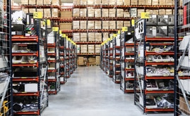 O armazém composto por estantes de paletização convencional, estantes de caixas para picking e um circuito de transportadores