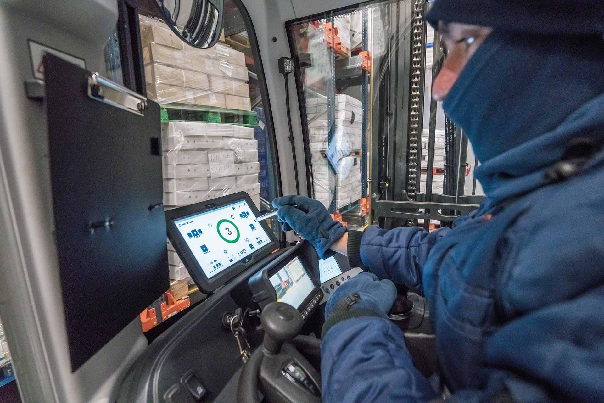 Um operador usa um tablet em uma câmara fria Um operador usa um tablet em uma câmara fria